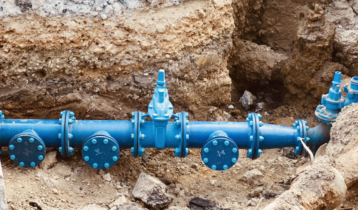 Water main pipe exposed and repaired in an excavated trench